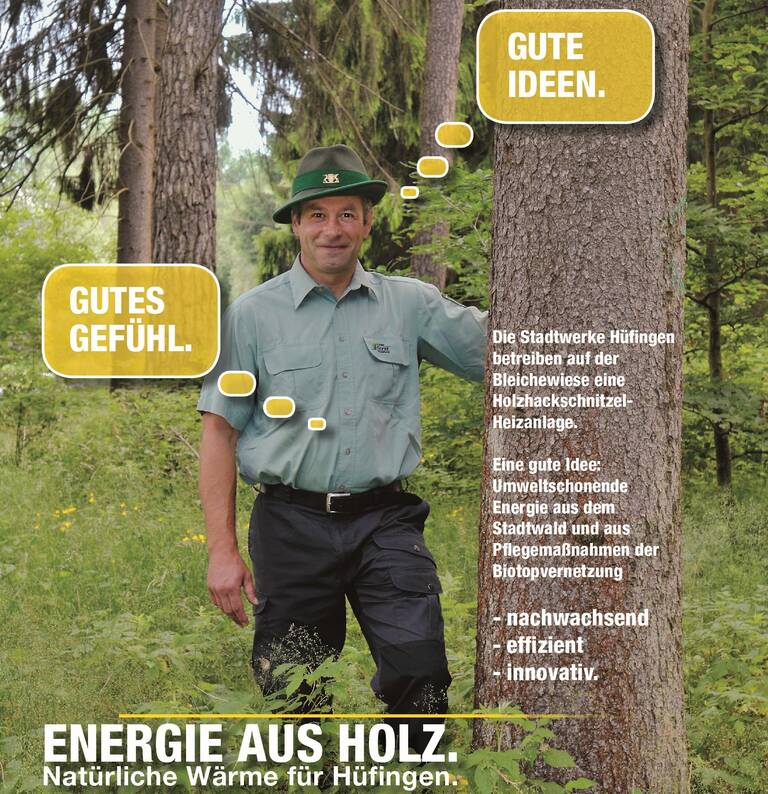 Ein Förster in Uniform steht lächelnd im Wald, während Sprechblasen positive Aussagen wie "GUTES GEFÜHL." und "GUTE IDEEN." anzeigen und der Text die Vorteile einer Holzhackschnitzel-Heizanlage betont.
