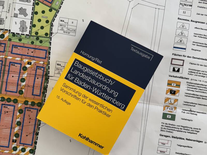 Gesetzbuch, das auf einem Bebauungsplan liegt.