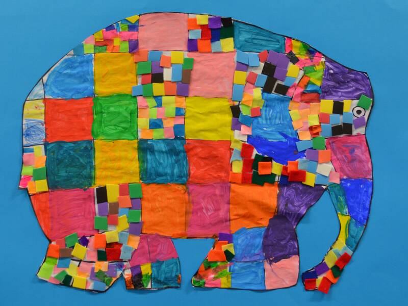 Ein farbenfroher Elefant aus quadratischen und rechteckigen Papierteilen in verschiedenen Farben auf einem blauen Hintergrund.
