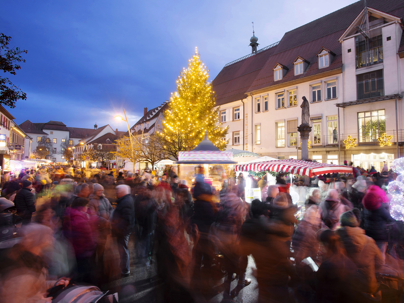 Kloosemärt mit vielen Besuchern. Im Hintergrund ist das Rathaus mit erleuchtendem Baum zu sehen 